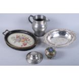 A silver inkwell, a pewter jug, a silver plated tray, a tray with inset needlepoint, and a small pot