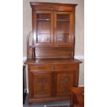 An Edwardian walnut cabinet, the upper section fitted glazed doors over two drawers and cupboards,