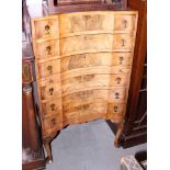 A figured walnut inverse bowfront chest of six long graduated drawers, on shell carved cabriole