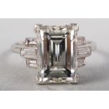 An Art Deco platinum ring set central emerald cut diamond, 3.52ct, set baguette cut diamond shoulder