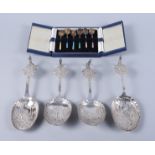 A set of four Dutch silver spoons, each decorated with village scenes with lion scrolled handles,