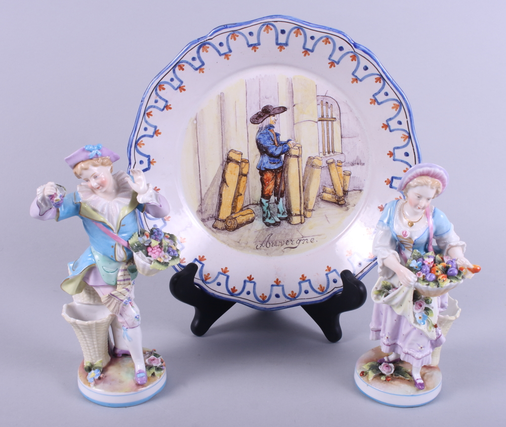 A pair of Continental porcelain figures, flower sellers, and a tin glazed plate, "Auvergne"