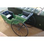 A Victorian three-wheel pram, painted in green and button upholstered in a black leather