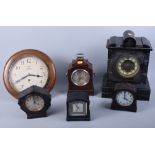 A selection of clocks, including a black slate mantel clock, a wall clock, three electric clocks and