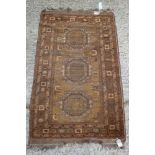 An Afghan gold washed rug with three medallions on an old gold ground, 39" x 65" approx