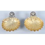 A pair of 800 grade silver shell-shaped dishes with gilt bowls and scrolled decoration, on shell