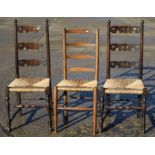 A pair of rush seat ladder back chairs and a similar ladder back chair