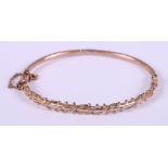 An Edwardian 9ct rose gold hinged bangle with rope twist and bead decoration, 5.4g