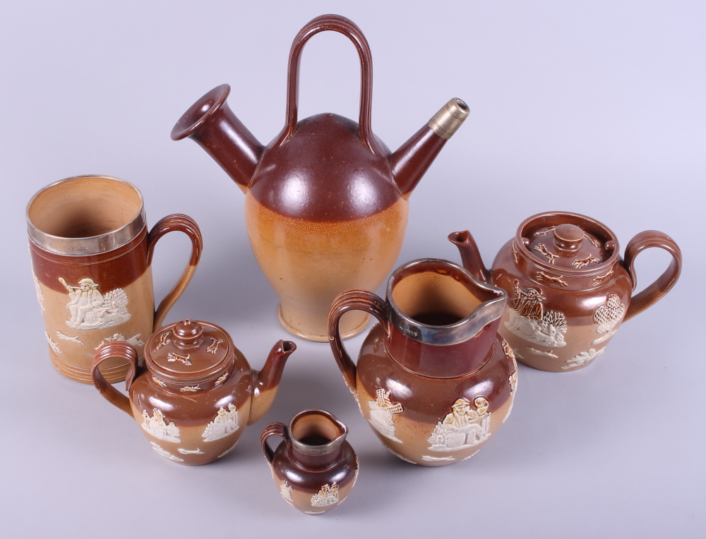 A Doulton Lambeth brown glazed pottery jug with silver rim, a similar tankard, two teapots and two