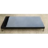 A modern black lacquered low coffee table, on brushed steel supports, top 27 1/2" x 55"