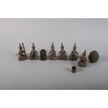 Six Indian white metal models of seated musicians, a Buddha and a rattle