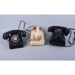 A Northern Electrics black Bakelite rotary dial telephone, a cream rotary dial telephone and another