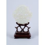 A pale celadon carved plaque, decorated peaches and a bat, on carved wood stand, 3 1/2" high