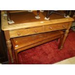 A pine desk with leather top, fitted two drawers, on turned and fluted supports, 42" wide, and an