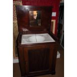 A 19th century mahogany washstand with lift up lid and enclosed panel door, 29" wide