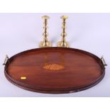 An early 20th century mahogany tray and a pair of brass candlesticks