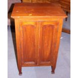 A mahogany bedside cupboard enclosed two arch top panel doors, on turned supports, 18 1/2" wide
