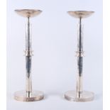 A pair of white metal candlesticks with planished decoration, marked 925, with white enamel on