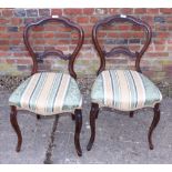 A pair of Victorian mahogany carved balloon back chairs, upholstered in a green, beige and white