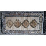 A North African rug with four hooked guls in shades of faun, brown, black and natural, 80" x 41"