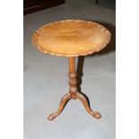 A walnut piecrust tilt top table, on carved tripod supports, 20" wide