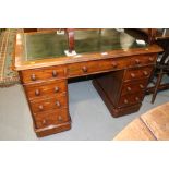 A late Victorian walnut double pedestal desk with green tooled leather lined top over nine