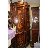 A Dutch marquetry bowfront corner cupboard with classical figures, vases of flowers, enclosed four