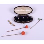 Two 19th century stick pins, mounted coral beads, a stick pin, set white and green stones, a gold,