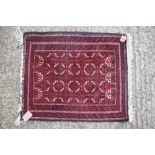 A Bokhara prayer mat with all-over geometric design, in shades of red, orange, black and natural,