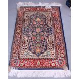 A Persian Qum silk machine-made rug decorated with flowers and vases on a red ground, with