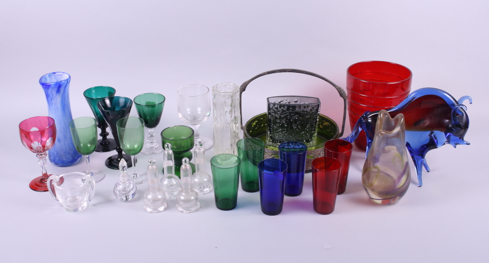 An assortment of glassware, including green tinted pedestal glasses, bark vases, a model of a