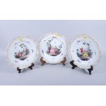 A set of three 19th century Meissen dessert plates with figure decoration and gilt borders, 10"