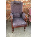 A Victorian carved mahogany framed elbow chair, upholstered in a blue and red fabric, on turned