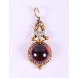 A Georgian gold and enamelled pendant set single garnet cabochon