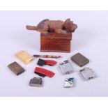 A carved wood box, decorated with a dog, containing military patches, a skiing badge and lighters,