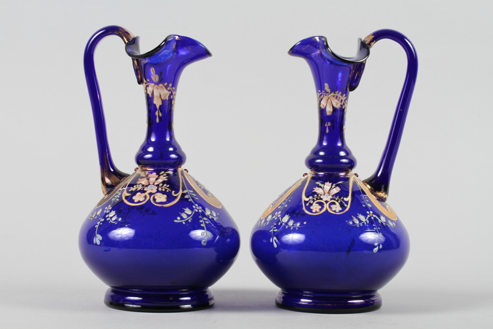 A pair of 19th century blue enamelled and gilt decorated glass ewers, 7" high