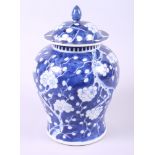 A late 19th century Chinese blue and white vase and cover with floral decoration (hairline crack