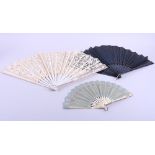A black lace fan with ebony and inlaid sticks, a lace fan with carved and painted mother-of-pearl