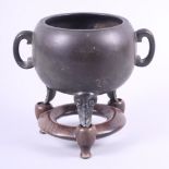 A Chinese bronze two-handled censer, seal mark to base, on three feet, with stand 6 1/4" high
