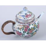 An 18th century Chinese porcelain teapot with all-over floral decoration, gilt highlights and wicker