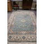 A Persian design rug with all-over leaf and scroll design on a green ground with cream floral