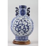 A 19th century Chinese blue and white moon flask, decorated dragons with a scrolled foliate