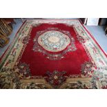 An Aubusson design carpet with sprays of flowers and central medallion on a crimson ground, 142" x