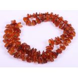 An amber pebble and tiger's eye bead necklace, 34" long, 93.2g, and a faux butterscotch amber bead