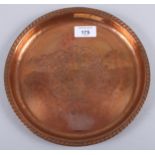 An Arts & Crafts design circular copper tray, decorated two birds, stamped Harold Holmes, 9 1/4"