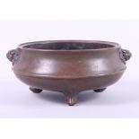 A Chinese bronze censer with lion mask handles, seal mark to base, on three feet, 3" high