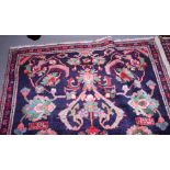 A Middle Eastern rug with floral patterns on a dark blue ground and multi-borders, 91" x 55" approx