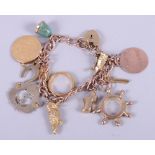 A 9ct rose gold charm bracelet with heart-shaped clasp, charms to include a Belgian twenty franc