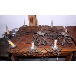 A wrought iron scroll work horizontal eight-light circling light pendant, 42" wide