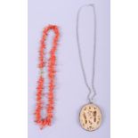 A coral twig necklace with yellow metal clasp, an Oriental white metal mounted roundel, decorated